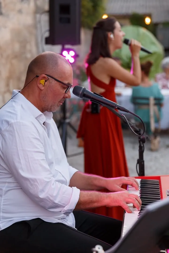 Le duo Mahkah en live : Stéphane au piano et Mathilde au chant en robe rouge, en soirée