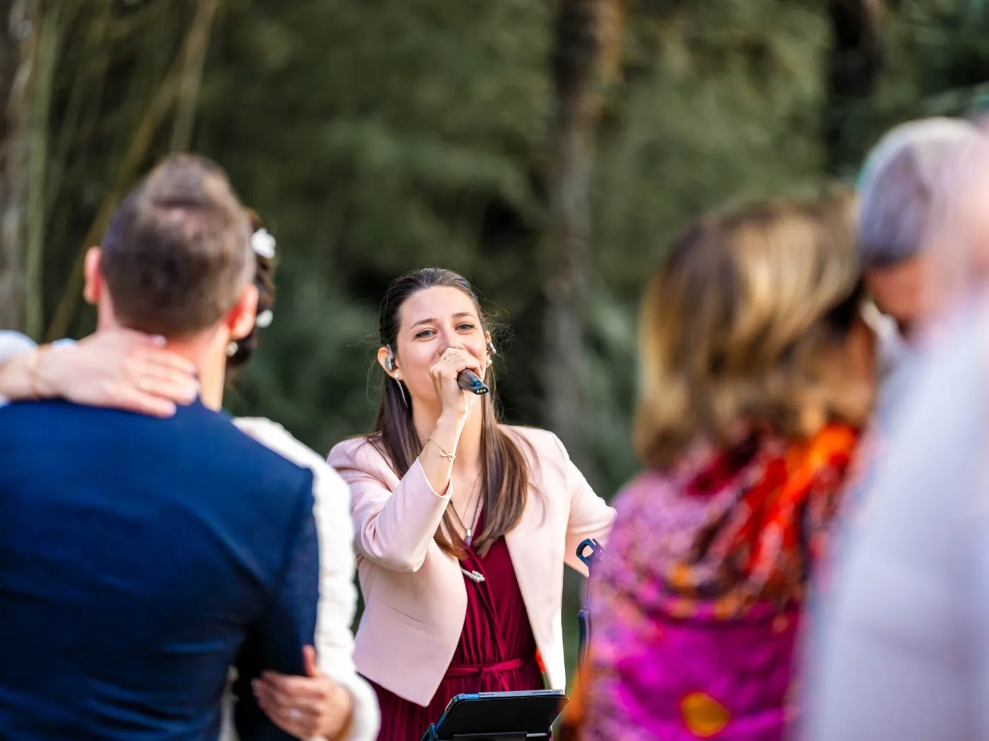 Mathilde chante au micro au milieu des invités lors d'un cocktail de mariage