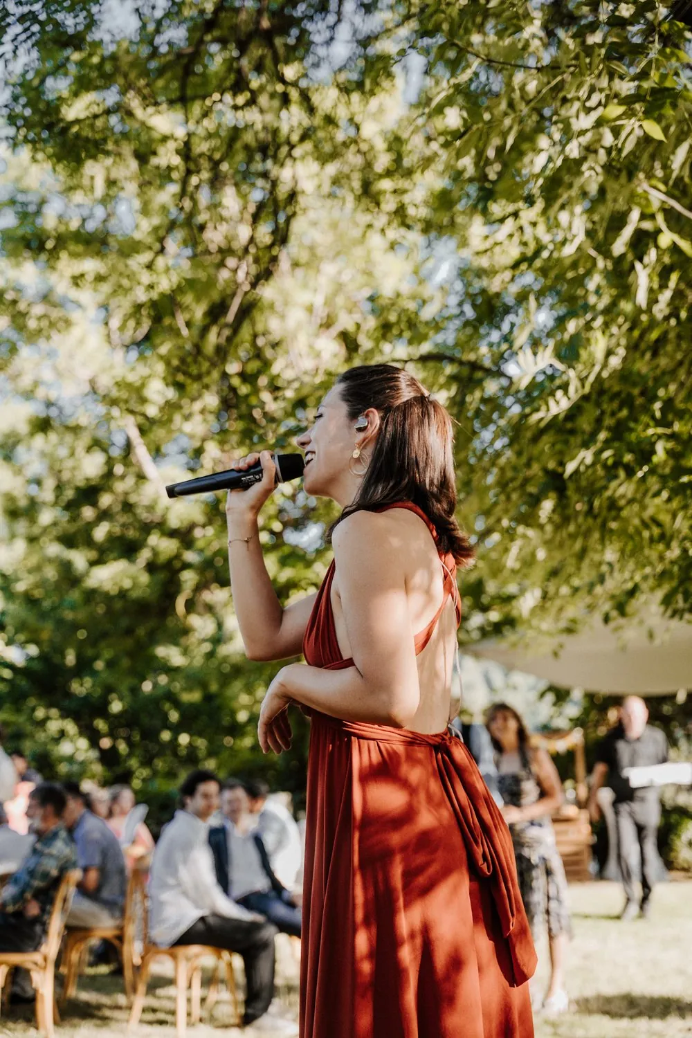 Mathilde chante face aux invités lors d'un cocktail de mariage en extérieur